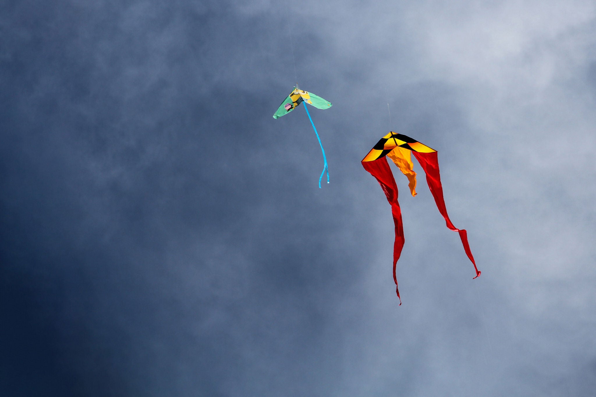 LOW ANGLE VIEW OF KITES FLYING IN SKY