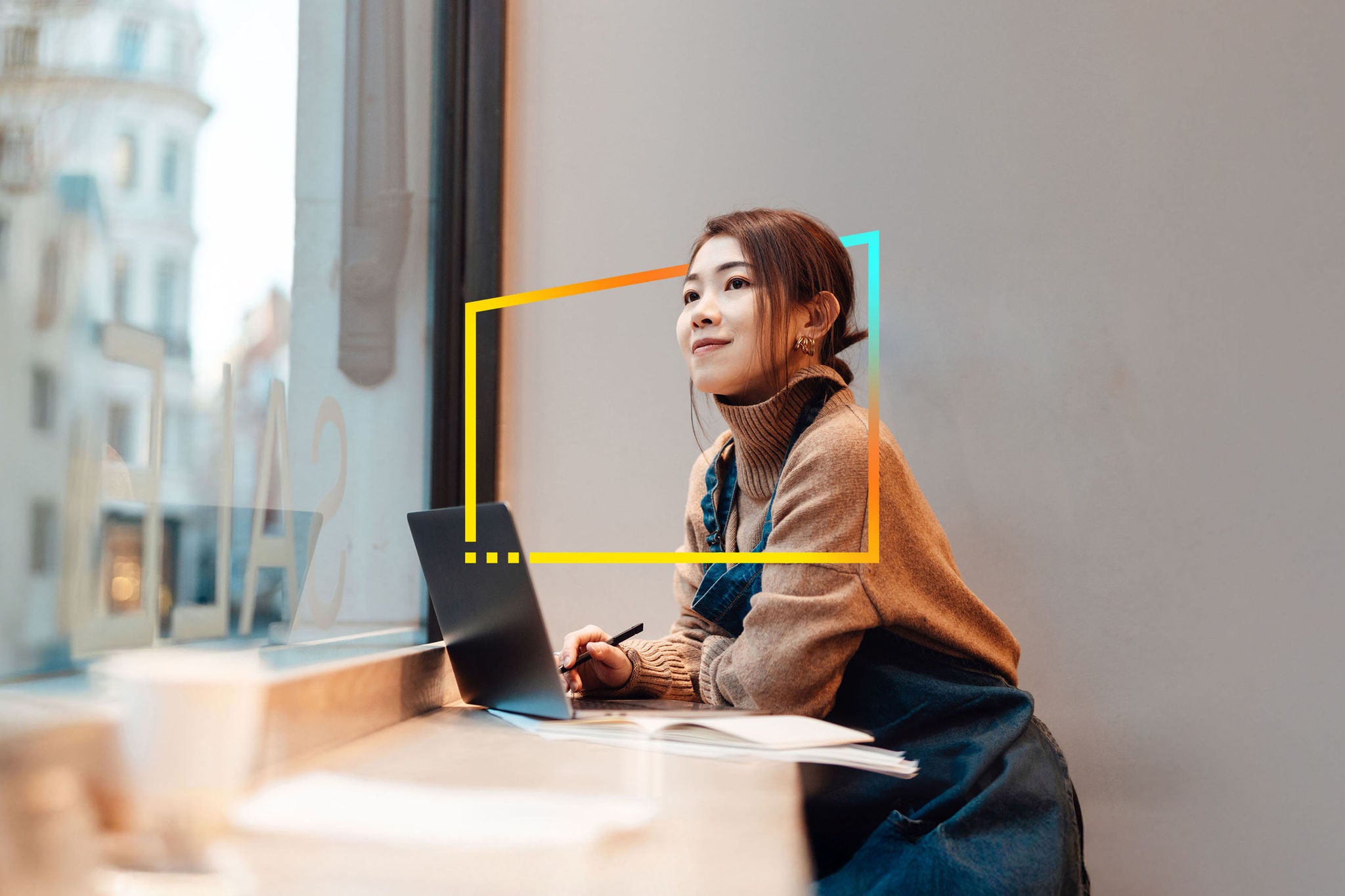 Female business owner doing accounting with laptop sitting in her cafe