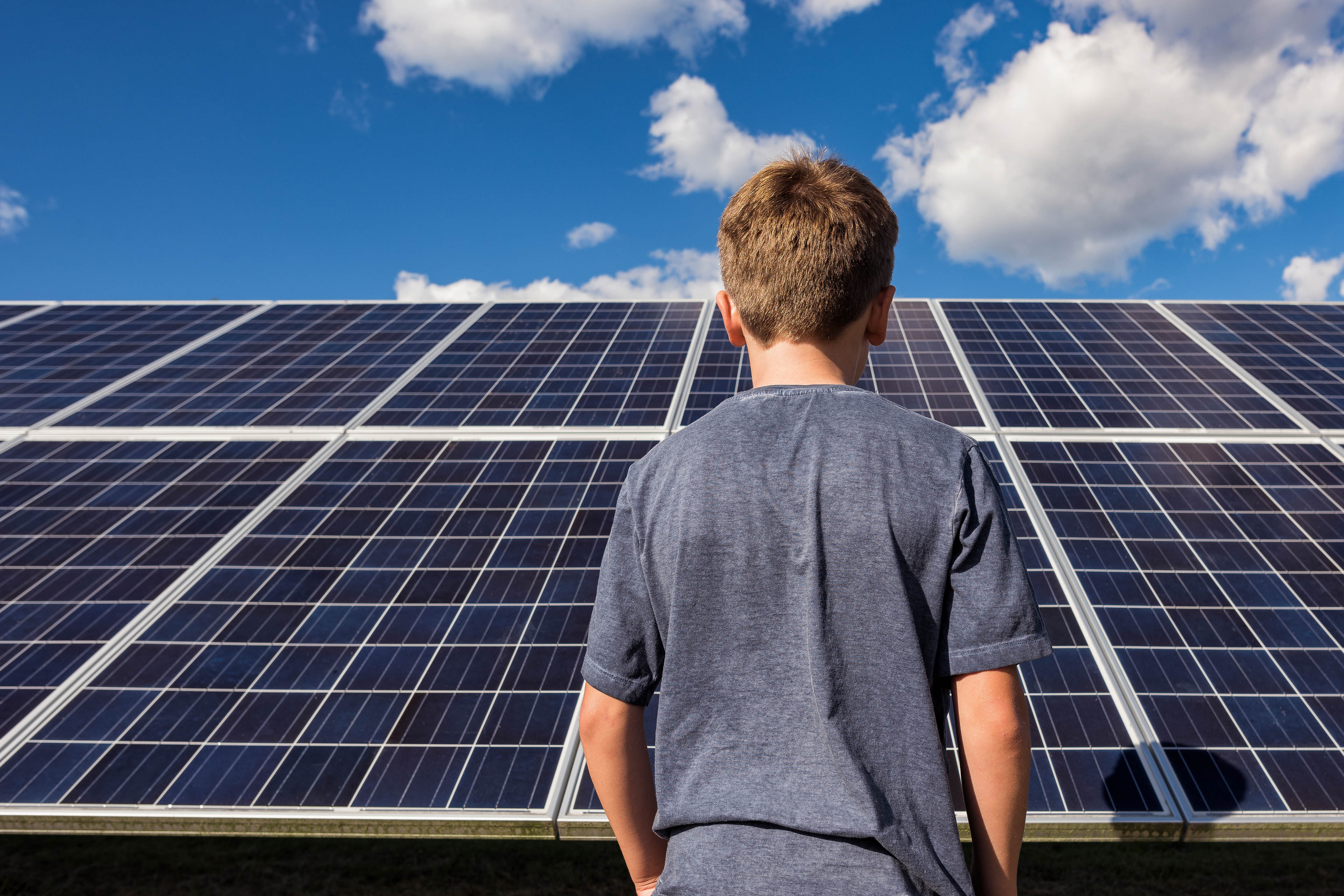 Boy standing in front of solar panels